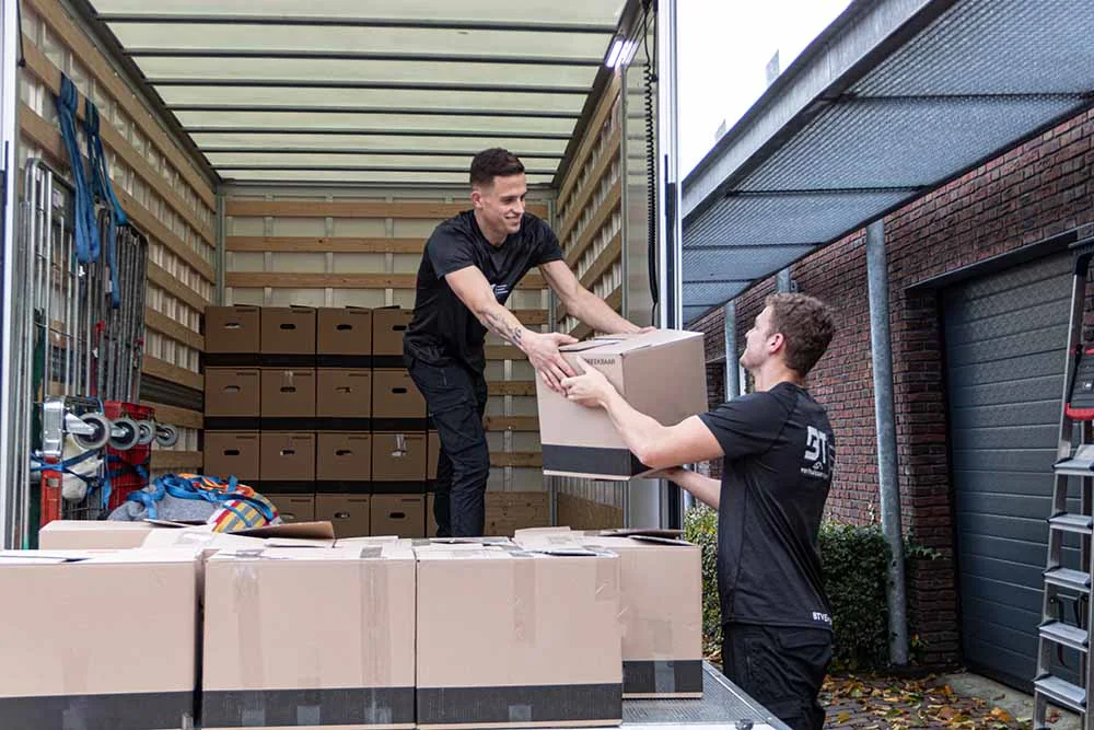 Verhuizers laden dozen in een verhuiswagen